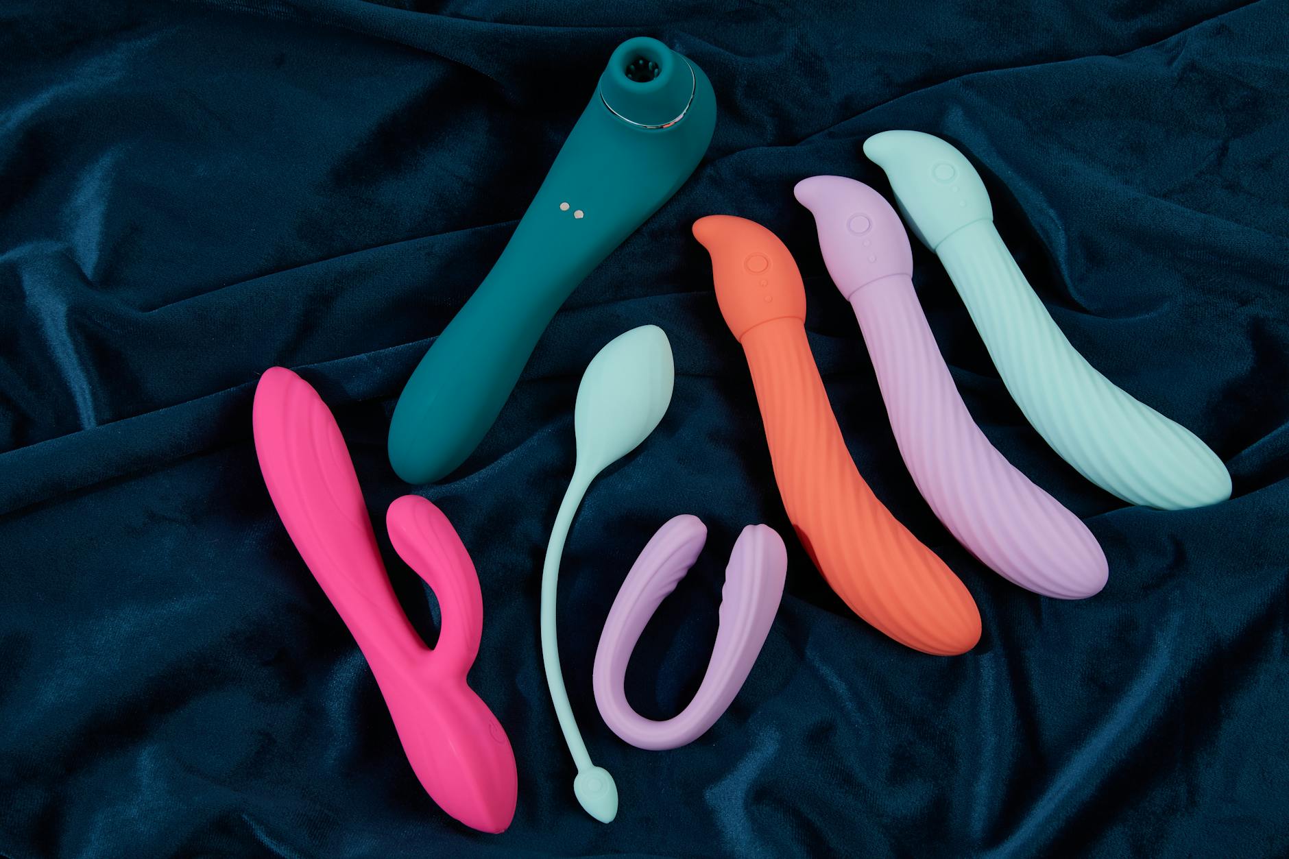 Yellow silicone vibrator surrounded by fresh bananas on a bright yellow background