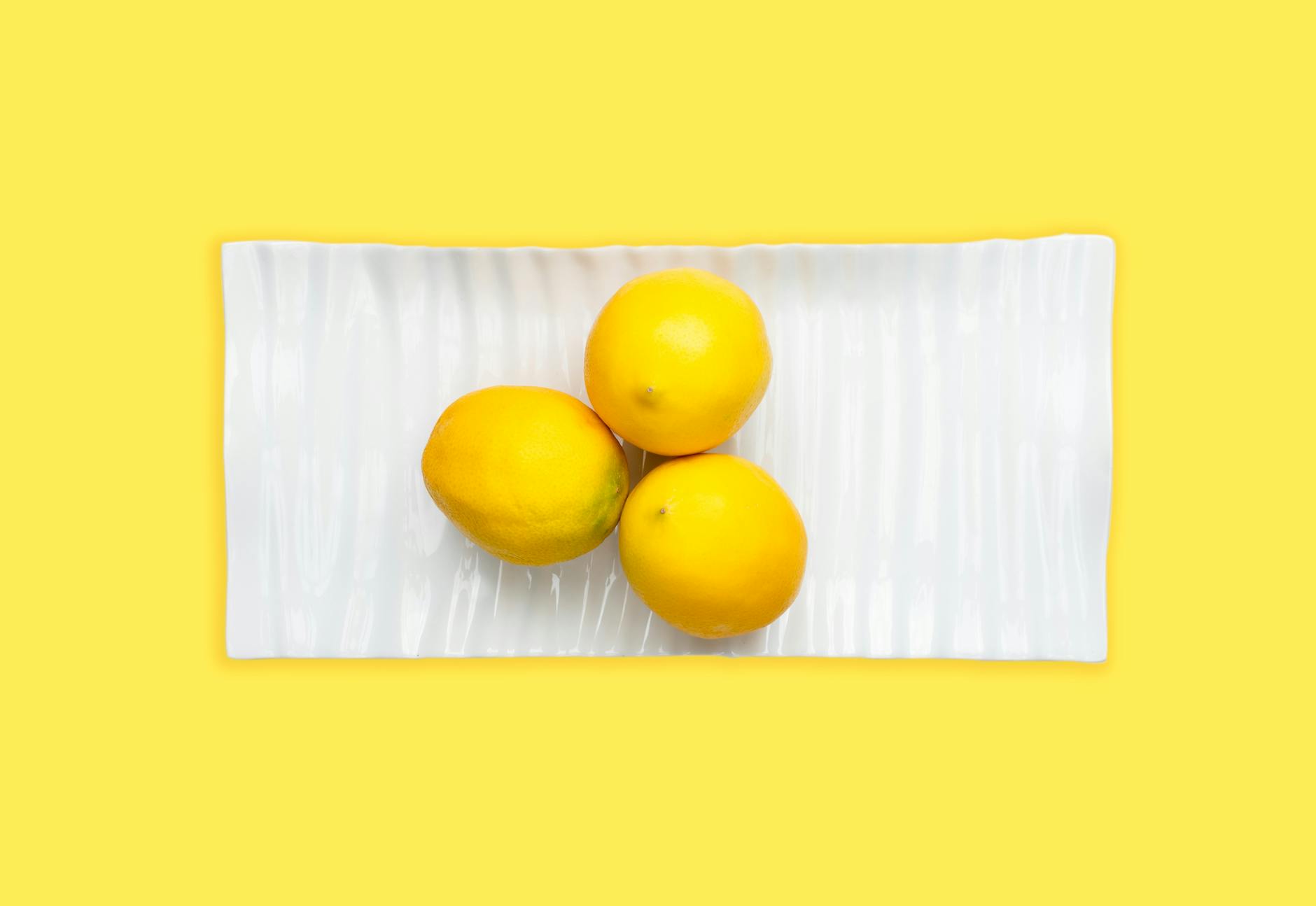 Bright yellow lemons arranged on a pastel green background, symbolizing renewed sensation and vibrant pleasure