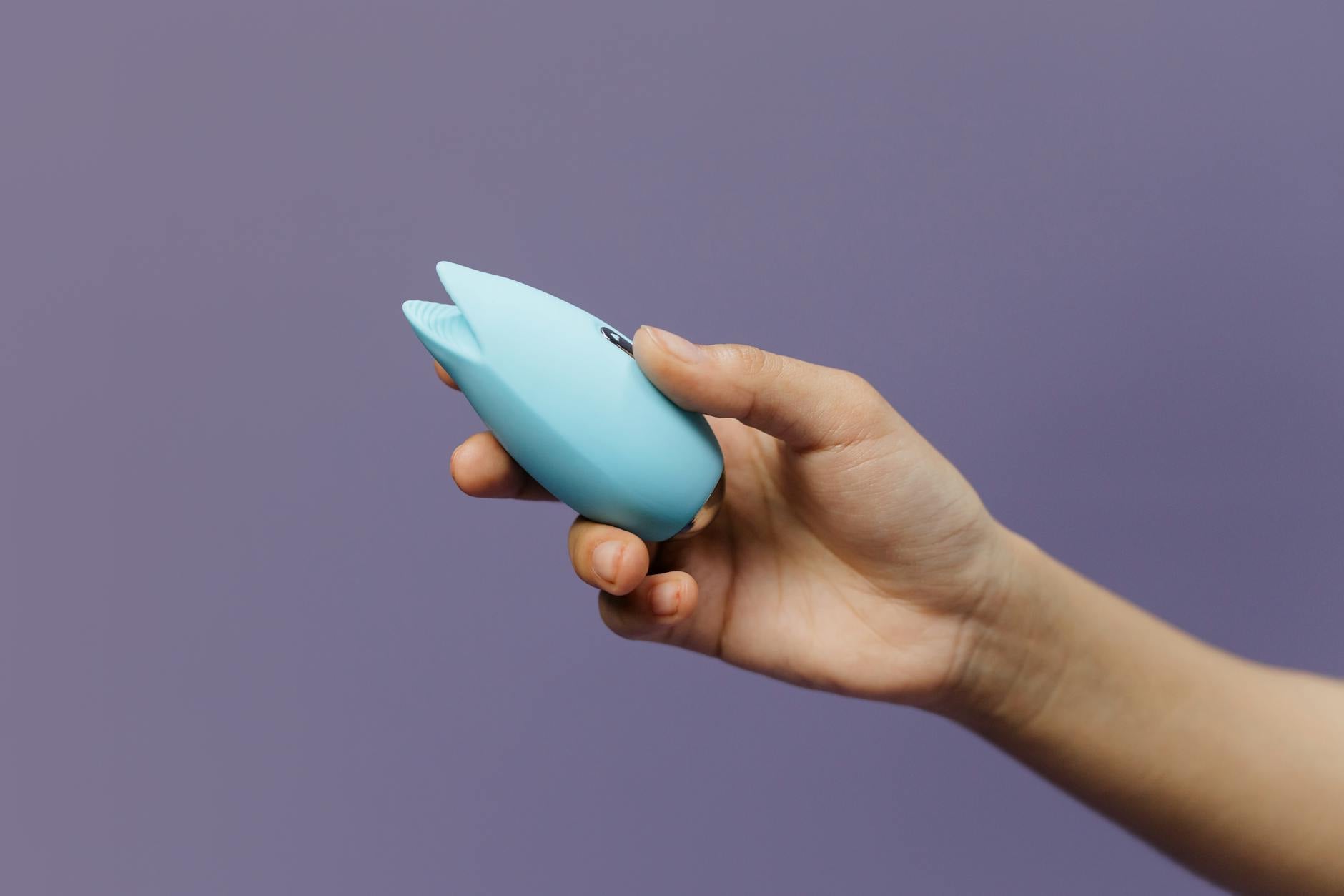 Woman holding lemon vibrator with contemplative expression